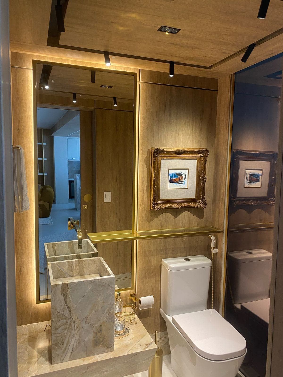 Lavabo com espelho iluminado e acabamento dourado
