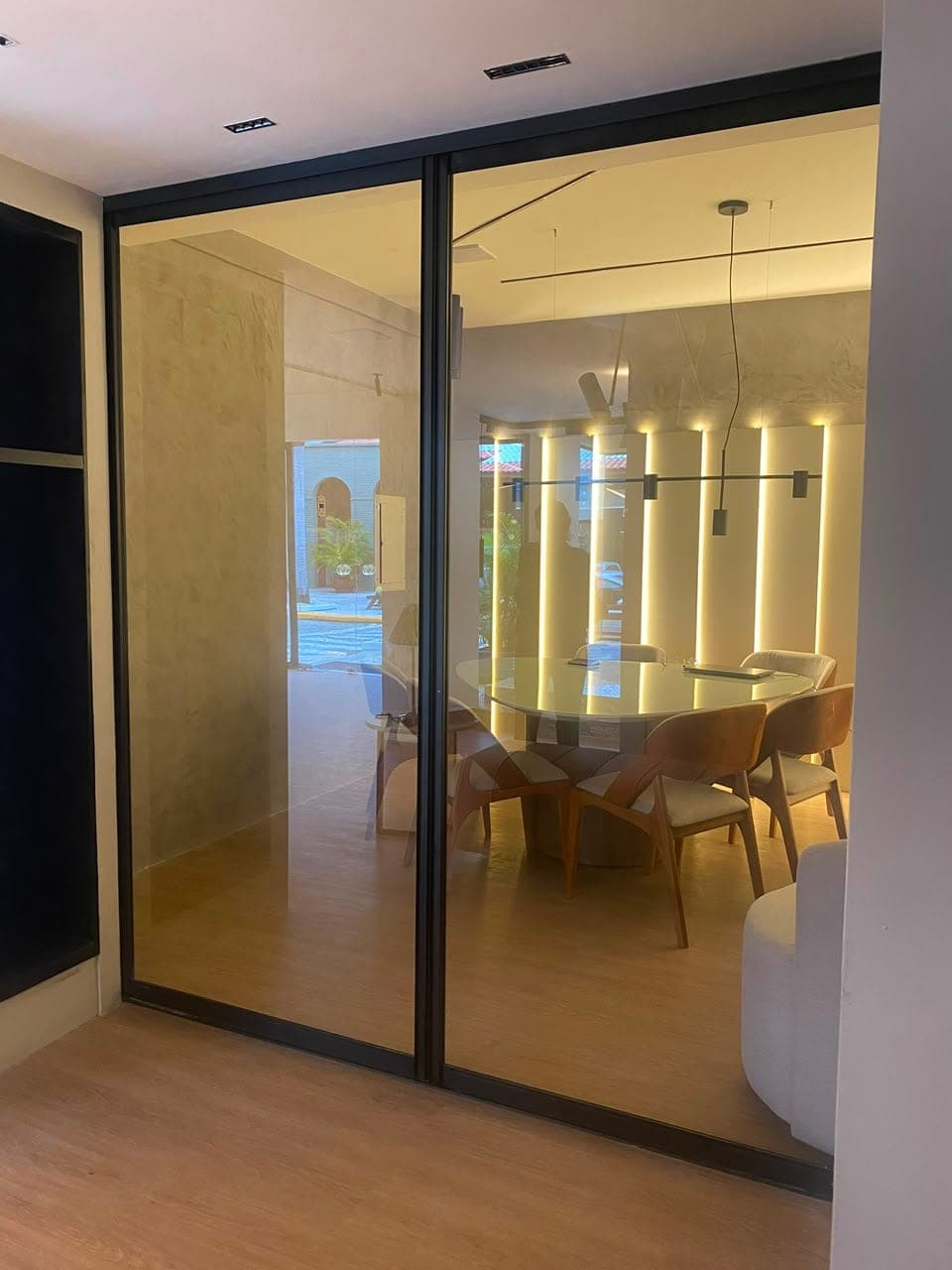 Sala de reunião com porta de vidro e estrutura de alumínio preto